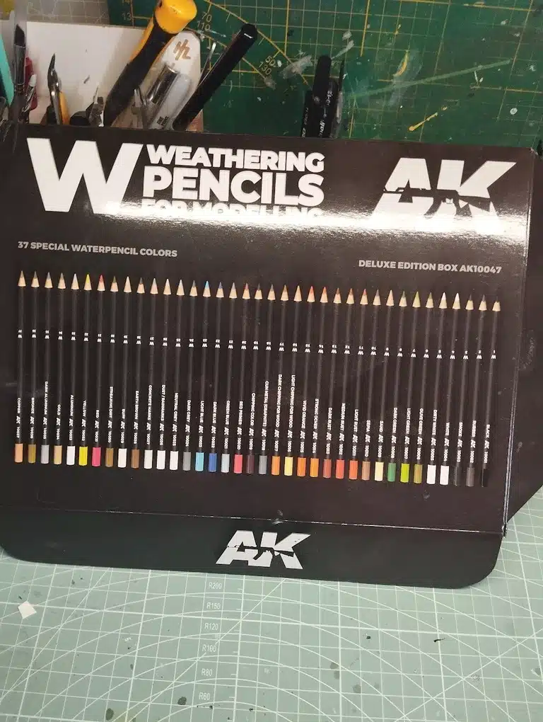 img src=cheminversimage.jpg alt=Boîte de 37 crayons de couleur pour modélisme de la marque AK Interactive, étiquetée 'Weathering Pencils for Modelling Deluxe Edition Box AK10047', avec des tons allant des couleu