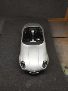 a silver toy car on a black surface